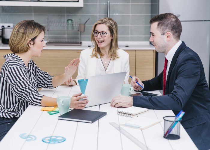 cheerful-colleagues-using-devices
