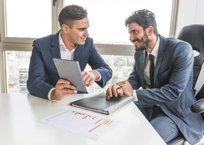 male-employee-showing-his-partner-digital-tablet-meeting
