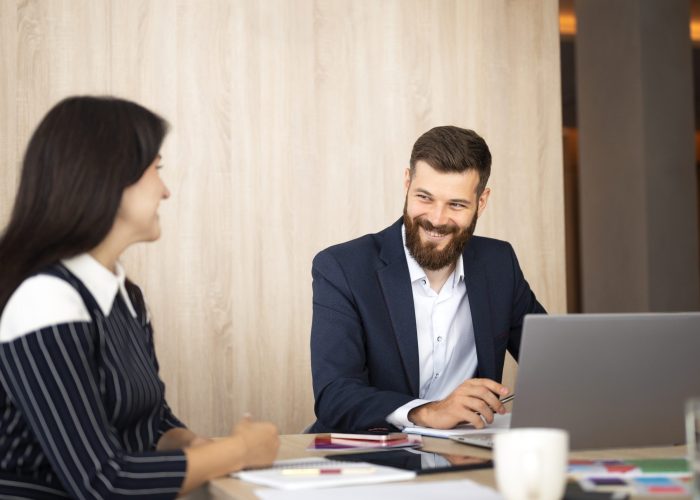 side-view-smiley-colleagues-working-with-laptop